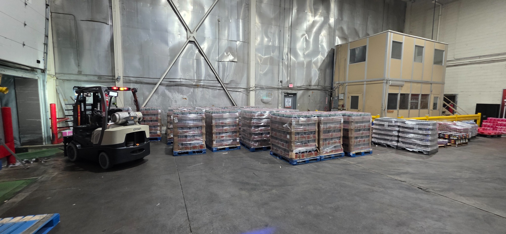 Completed beverage load restack with multiple wrapped pallets staged in a warehouse dock area.