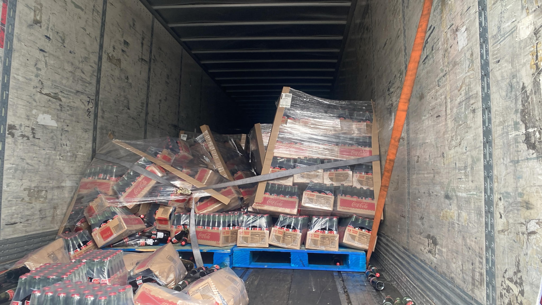 Collapsed beverage load inside trailer before emergency restacking work begins.