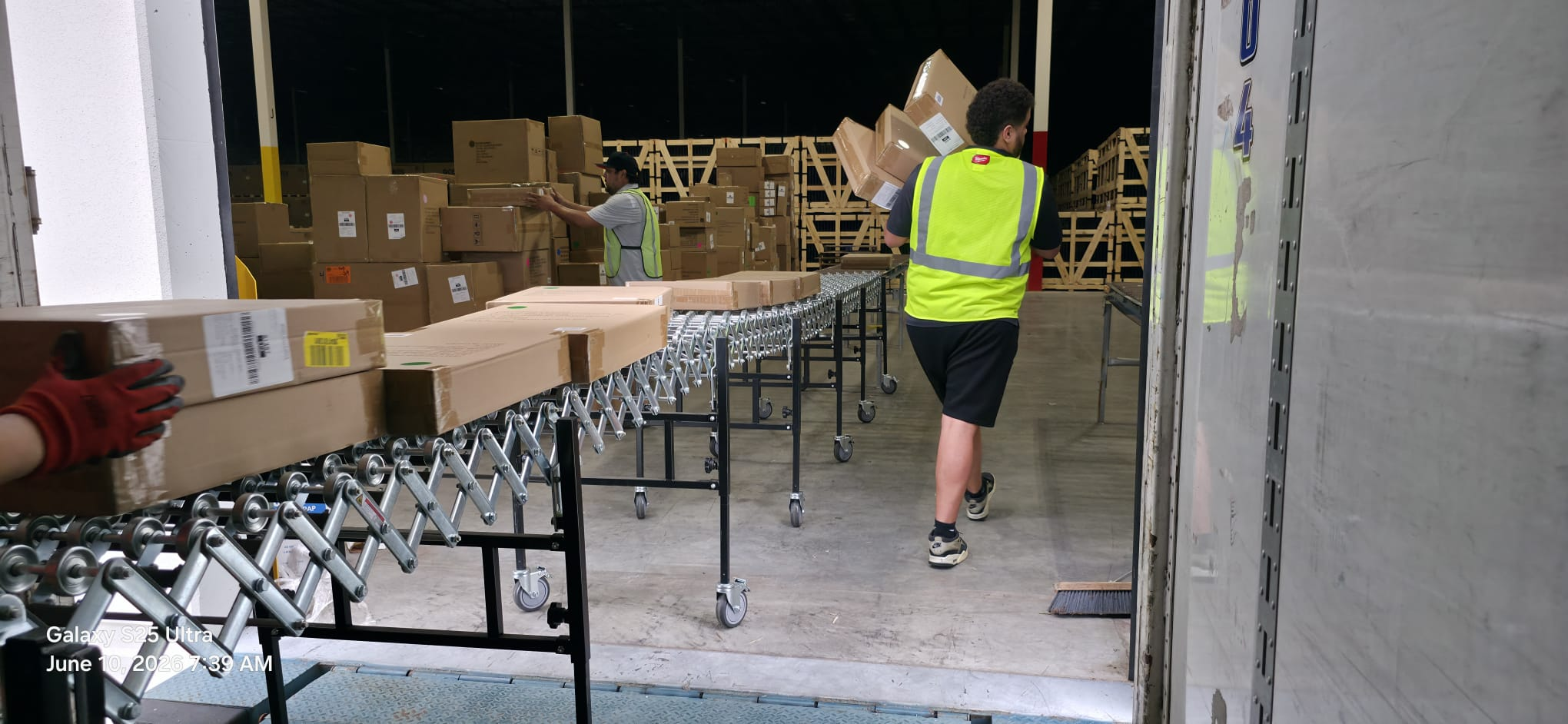 Warehouse staffing crew unloading and sorting freight on a conveyor line